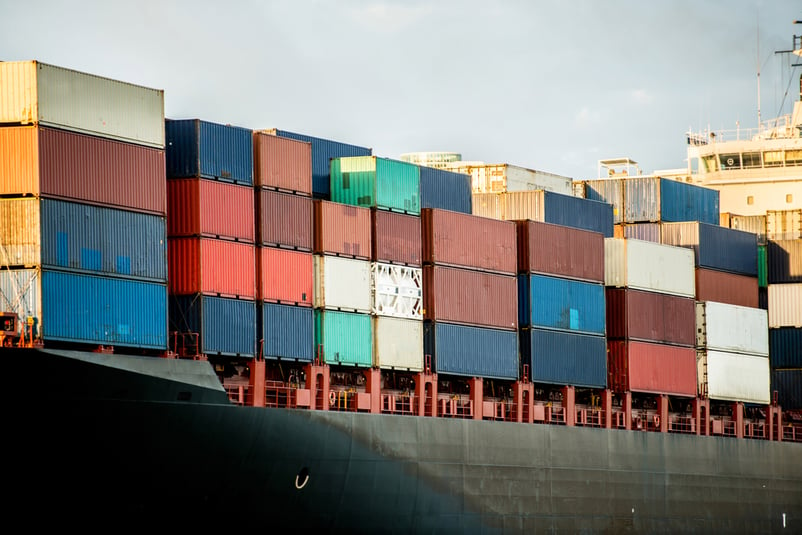 Trade boat carrying containers and arriving at the port